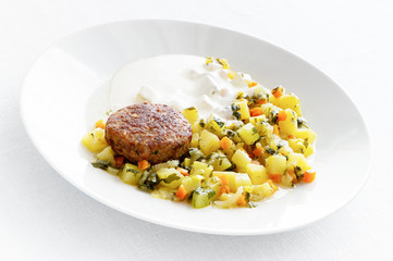 turkey meatball garnished with potato, courgette, and carrot stew with herbs and sour cream