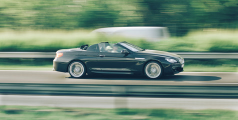 Car driving fast on highway motion blur