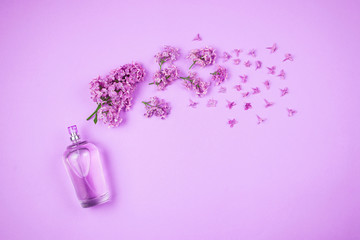 Flatlay with violet lilac flowers and perfume bottle