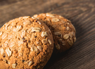 Oatmeal cookies with a sprinkling of oat flakes and seeds on a wooden background