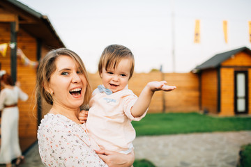 Mom holds a baby and air balloons and have fun. Birthday party