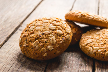 Oatmeal cookies with a sprinkling of oat flakes and seeds on a wooden background