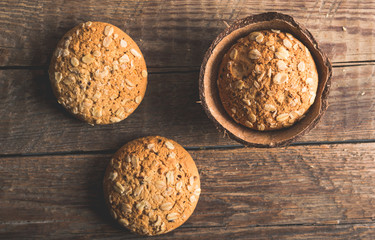 Oatmeal cookies with a sprinkling of oat flakes and seeds on a wooden background