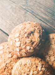 Oatmeal cookies with a sprinkling of oat flakes and seeds on a wooden background