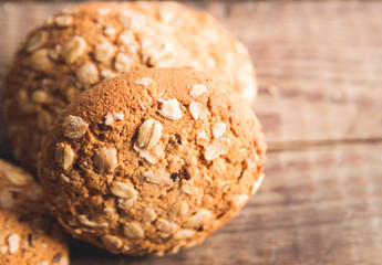 Oatmeal cookies with a sprinkling of oat flakes and seeds on a wooden background