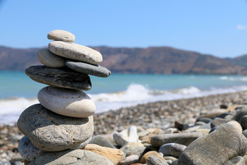 Fototapeta na wymiar Pebble stack by the ocean Crete