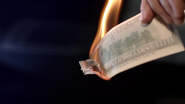 Male hand burning dollar banknote. Man burning money cash. Financial crisis and depressed economy. Paper money loss concept. Fire money concept