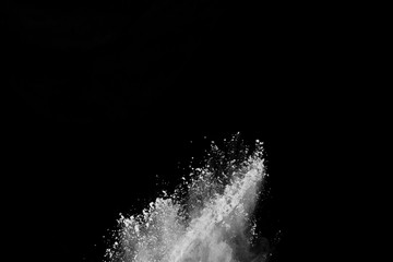  Freeze motion of white dust explosion on black background. Stopping the movement of white powder on dark background. Explosive powder white on black background.