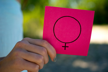 gender equality concept, a piece of paper with a female symbol in a woman's hand