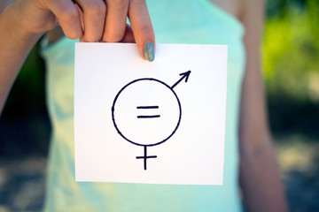 gender definition concept, a piece of paper with a female and a male symbol in a woman's hand