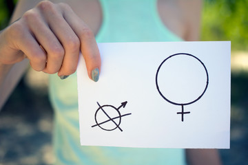 gender hegemony concept, a piece of paper with a female and a male symbol in a woman's hand