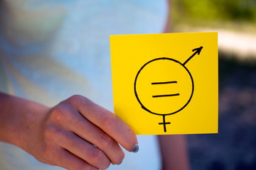 gender equality concept, a piece of paper with a female and a male symbol in a woman's hand