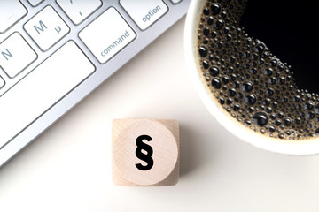 Würfel mit Paragraph Symbol am Arbeitsplatz