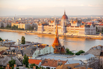 Obraz premium Widok na panoramę miasta ze słynnym budynkiem Parlamentu w świetle słońca w Budapeszcie, Węgry