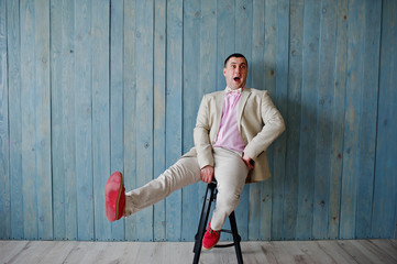 Studio portrait of man in suit against wooden background.