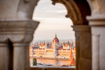 Obraz premium View through the arch on the famous Parliament building during the sunset in Budapest, Hungary