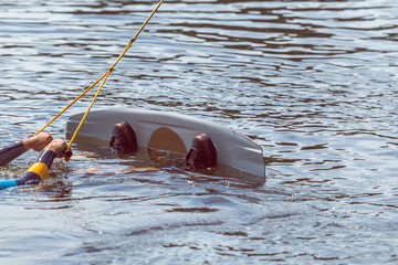 Summer time wake board extreme water sports concept. Man in the water with wakeboard ready to go wakeboarding. Vacation, holiday getaway fun with friends and family