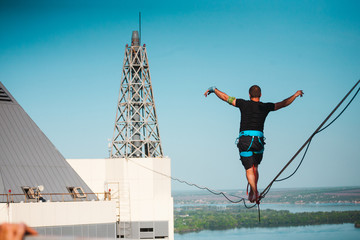 The man is balancing over the city.