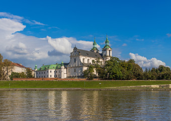 Obraz premium Krakow, Poland - the second biggest city in Poland, Krakow offers a mix of history and modernity. Here in the picture a perspective of the Old Town see from the Vistula river, which cuts the city