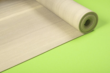 Yoga mat on green background with copyspace.