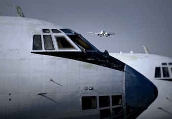 Fototapeta na wymiar Modern Passenger Aircraft Landing Over Old Planes At The Airport 