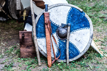 Knight shield, sword and ax in front of the tent. Medieval knight equipment weapons at middle age...