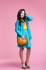 Beautiful woman in fashion clothes on pink background