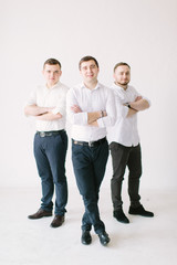 stylish groom in suit posing with groomsmen in garden on wedding day. luxury men in rich outfits standing together. friendship