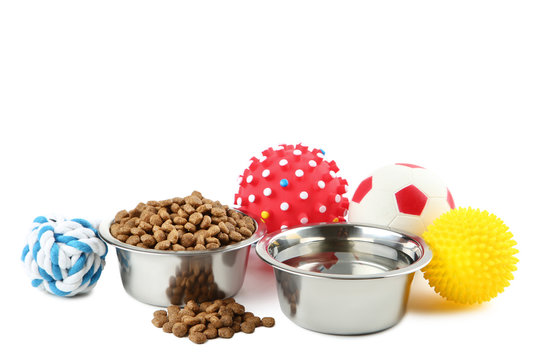 Pet toys with cat food and water in bowls on white background