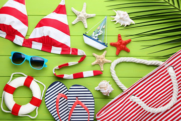 Summer accessories with seashells and palm leaf on wooden table