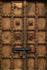 vintage wood door with brass fixtures bolt lock and padlock