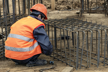 worker at the construction site makes rebar carcass