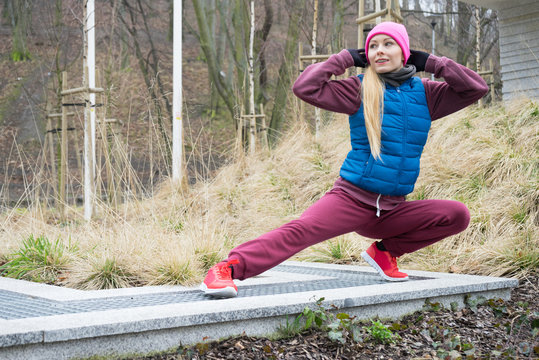 Sporty girl stretching outdoor in park.