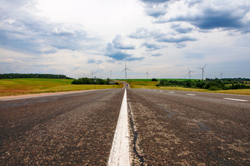 Road, clouds and wind turbines
