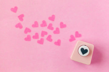 Decoration for Valentine's Day: hole puncher made paper shapes of pink hearts