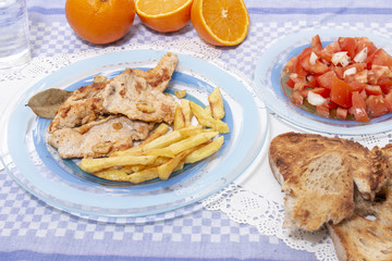 Turkey steak with french fries and tomato salad