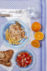 Turkey steak with french fries and tomato salad