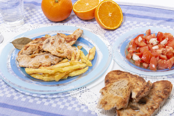 Turkey steak with french fries and tomato salad