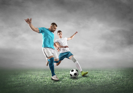 Soccer player on a football field in dynamic action at summer day