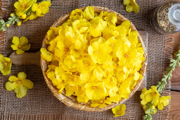Fresh mullein flowers in a wicker basket, top view