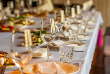 crystal wine glasses and a glass for juice on the banquet table
