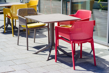 tables and chairs on the street on a sunny day near a cafe