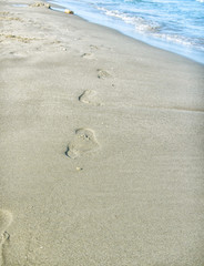 Sand beach, wave and footprints