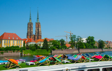 Recreation zone with chairs on the top of the ship against river and Tumski Island. Wroclaw, Poland.