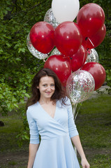 happy woman with party birthday baloons outdoor in summer. Ready to fly away.