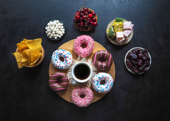 Donut sweets and Turkish sweets on a black table.