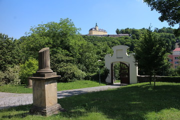 Fototapeta na wymiar Garden near Chapel of St. Roch and Sebestian and Fulnek castle in background, Czech republic
