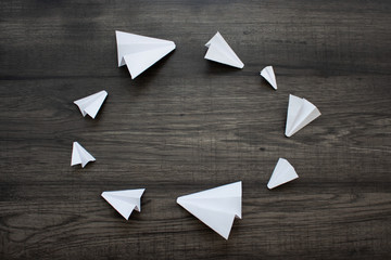 White paper planes on a wooden background. Telegram symbol