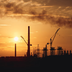 Silhouette power plant with cooling towers against sunset sky