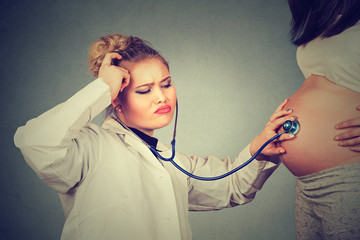 Doctor listening to pregnant patient